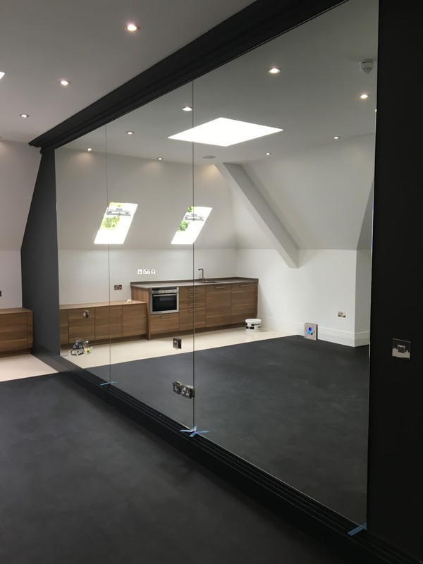 Frameless glass partition in loft conversion by Kentish Town glaziers