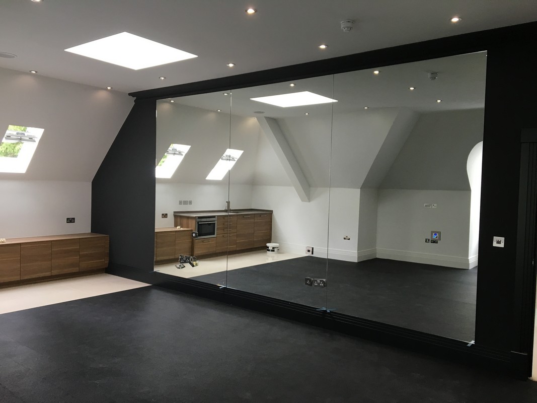 Frameless glass wall dividing loft conversion in Kentish Town