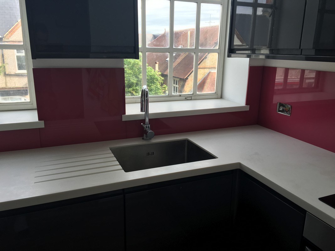 Deep plum coloured glass splashback in modern Kentish Town kitchen